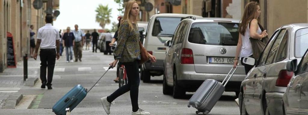 Dos turistes es dirigeixen al seu allotjament a la Barceloneta