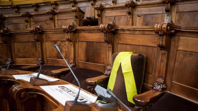 Silla que ocupó el preso Joaquim Forn en el salón de plenos que dirige Colau cuando fue concejal de Barcelona, vacía y con un lazo amarillo.