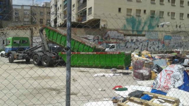 Un camión recoge los restos de la acampada de los sinhogar en Arc de Troimf / @xdrets
