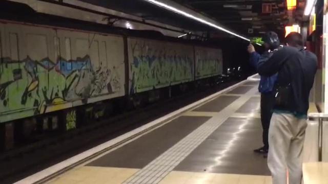 Dos de los grafiteros graban el convoy con sus pintadas, con el metro parado, en la estación de Selva de Mar / MÒNICA TUDELA EL PERIÓDICO DE CATALUNYA