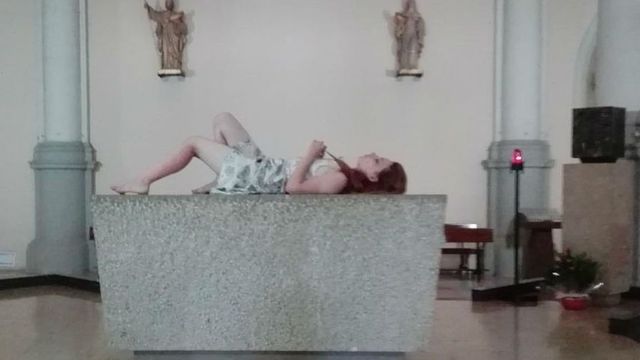 Una turista se tumba en un altar de una iglesia de la Barceloneta / LA VANGUARDIA
