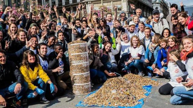 Decenas de voluntarios muestran su satisfacción junto a los restos de colillas recogidas durante este sábado / HUGO FERNÁNDEZ
