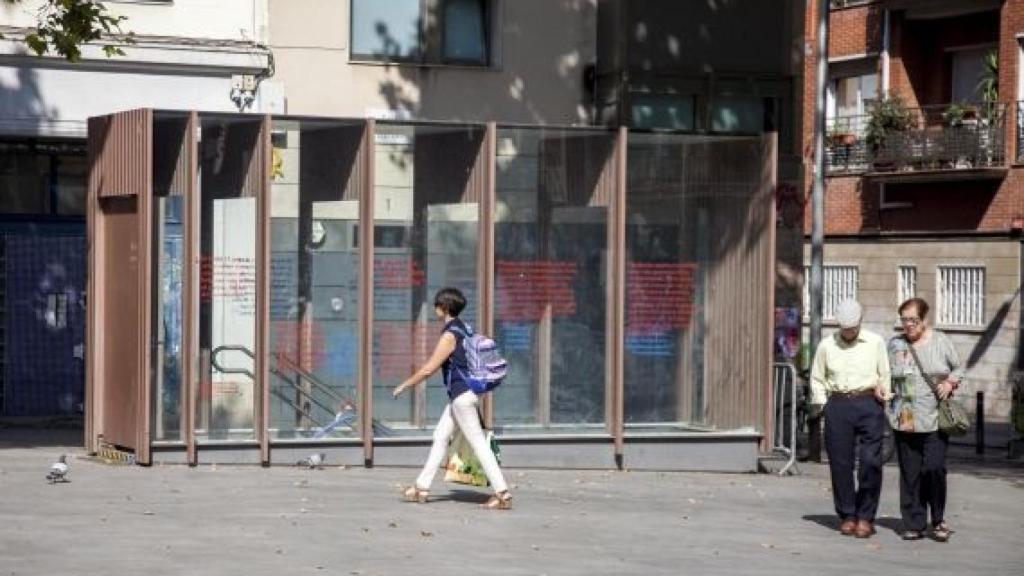 Veïns passejant per la plaça, amb l'entrada al refugi antiaeri al fons / Hugo Fernández