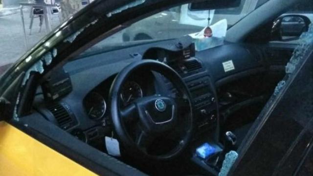 Un taxi con la ventanilla delantera rota
