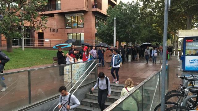 Cola de personas esperando un regalo a la puerta del metro