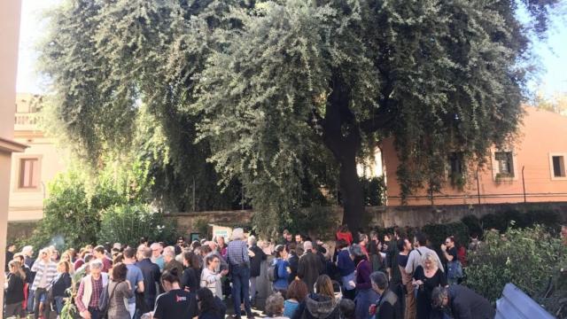 Los vecinos reunidos alrededor de la encina en la calle Encarnació