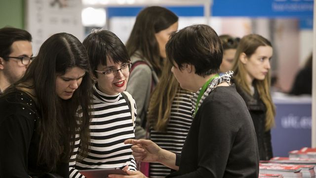 Una asesora atienda a dos estudiantes en el Salón del Futura