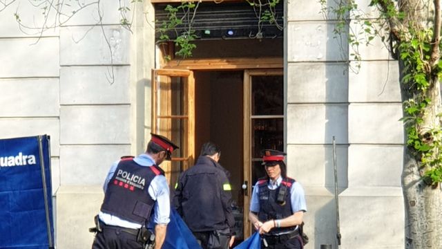 Agentes de los Mossos recogen la lona en la avenida de Mistral