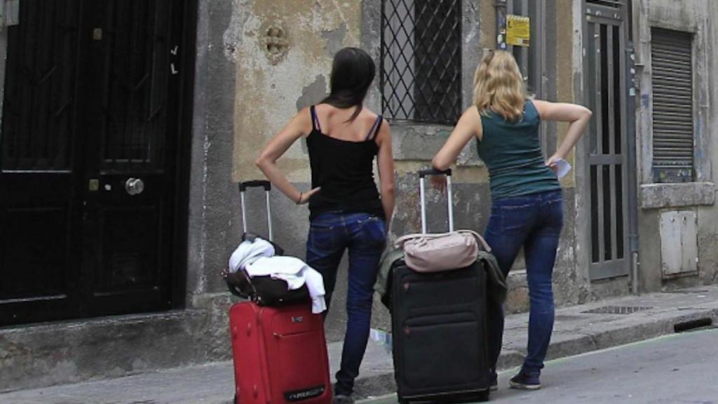 Dos turistes esperen a la porta d'un pis turístic a Barcelona / EFE