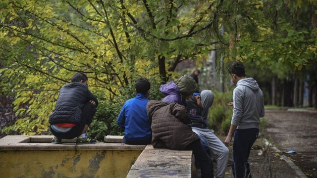 Jóvenes sentados en una barandilla de piedra / Fundació Arrels