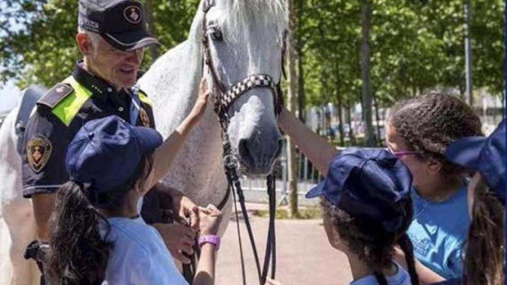 Un agent de la unitat muntada amb un grup de nens / SAPOL