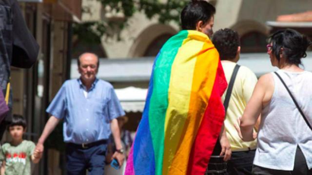 Una pareja camina por Barcelona con la bandera arcoiris contra los ataques homofóbos, emblema del colectivo LGTBI / EFE