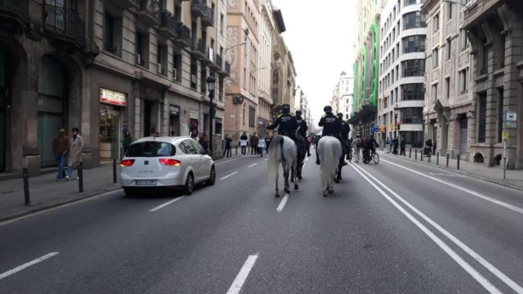 Agents de la Guàrdia Urbana a cavall al costat d'un cotxe a Via Laietana / M A