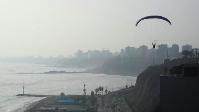 Una persona en paracaídas por encima de Barcelona