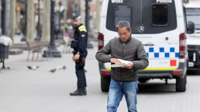 Un ciudadano tras ser multado por la Guardia Urbana de Barcelona / EFE