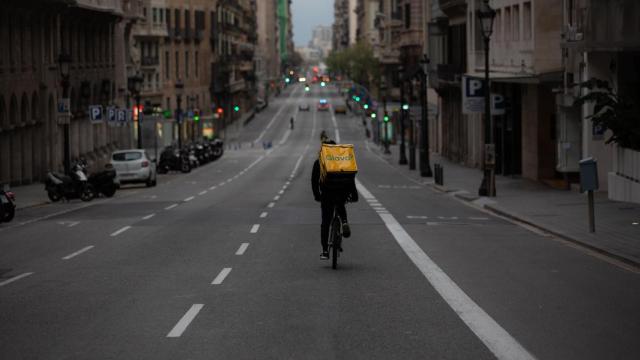 Un trabajador de Glovo circula en bicicleta por la vía Laietana de Barcelona