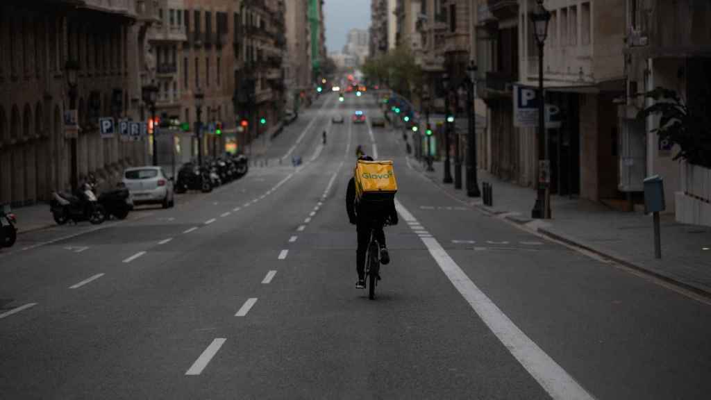 Un trabajador de Glovo en bicicleta por la vía Laietana de Barcelona