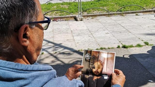 Un indigente mira la foto del presunto asesino / G A