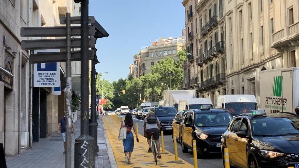 Una peatona y un ciclista utilizando a la vez el carril amarillo de la via Laietana en su parte más ancha / V.M.