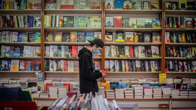 Un joven observa un libro de la papelería Demos, en Barcelona / EUROPA PRESS - David Zorrakino