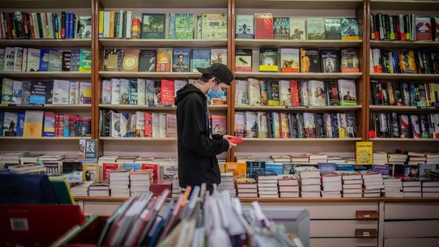 Un joven observa un libro de la papelería Demos, en Barcelona / EUROPA PRESS - David Zorrakino