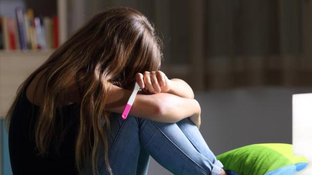 Una chica adolescente con un test de embarazo en la mano