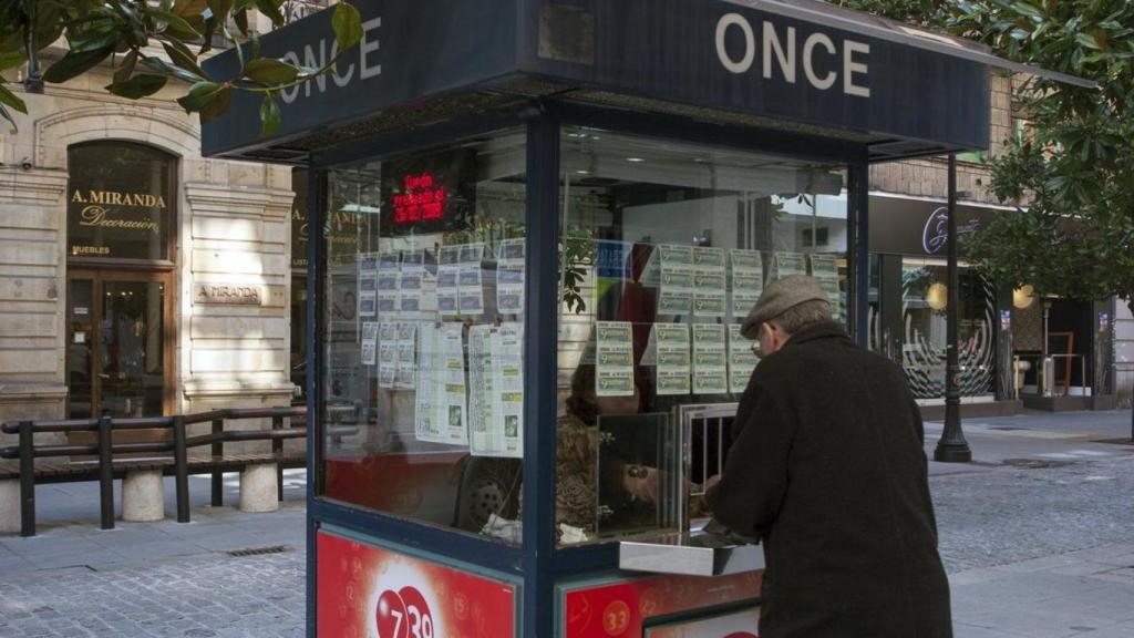 Quiosc de l'ONCE amb una persona comprant en una imatge d'arxiu
