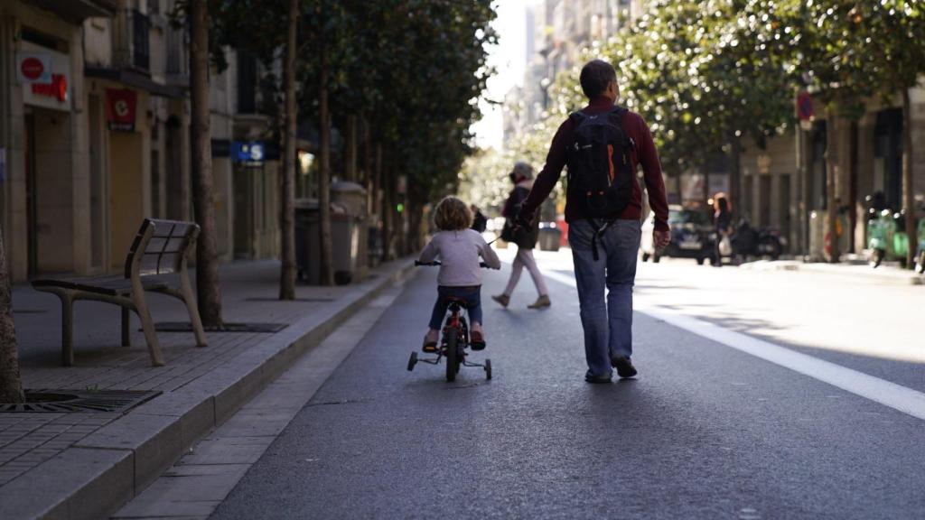 Un home passeja amb una nena al carrer Gran de Gràcia / AJUNTAMENT DE BARCELONA