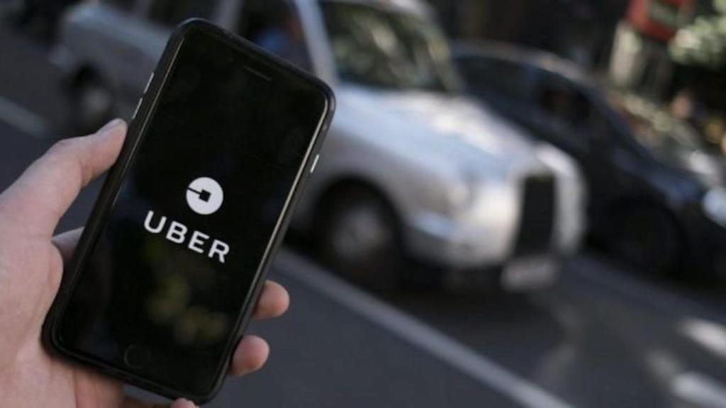 Un client obre l'aplicació d'Uber al mòbil / EFE
