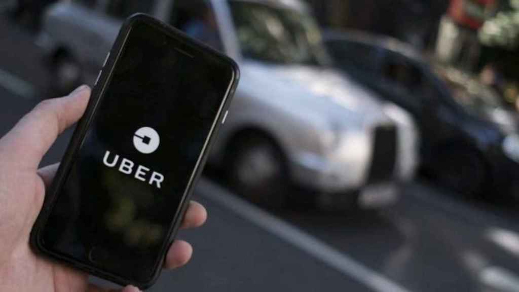 Un client obre l'aplicació d'Uber al mòbil / EFE