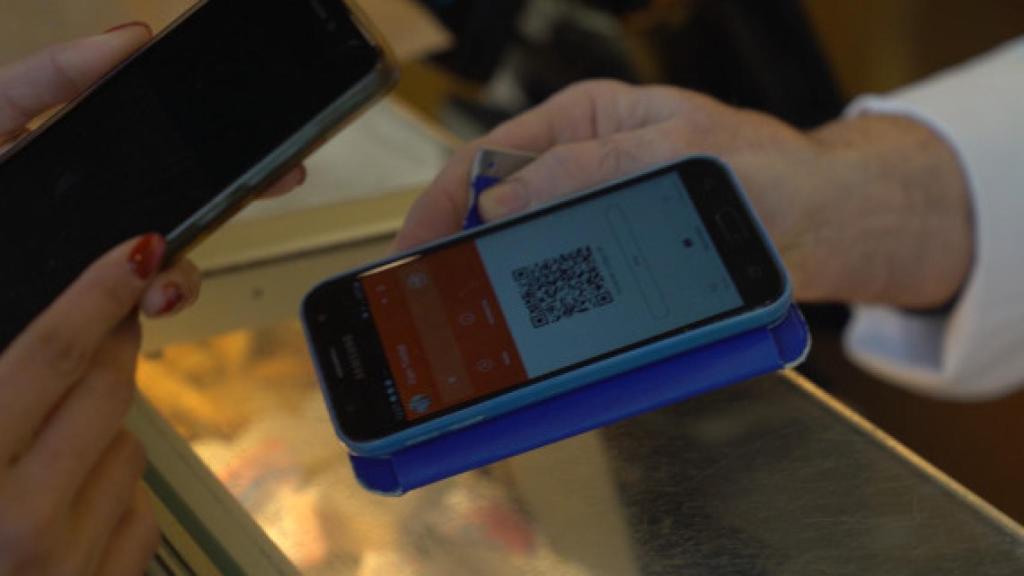 Una dona obre l'aplicació del mòbil per pagar amb la moneda REC / AJUNTAMENT DE BARCELONA