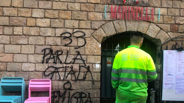 Operario de limpieza de grafitis limpiando la puerta del restaurante italiano atacado por grupos radicales independentistas / E.G.