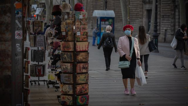 Una mujer frente a una tienda de artículos turísticos en Barcelona / EUROPA PRESS - David Zorrakino
