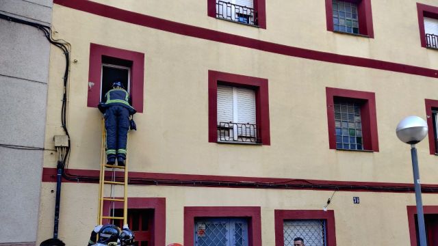 Un bombero asomándose a la ventana desde donde Pep amenazó con tirarse / TWITTER-Sindicat d’Habitatge de Nou Barris