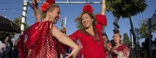 Mujeres bailan sevillanas en la Feria de Abril / EFE