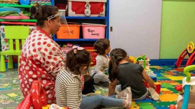 Niños juegan con la maestra en una guardería de Barcelona / EFE