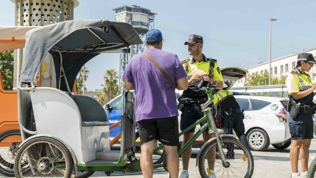 Unos guardias urbanos multan al conductor de un bicitaxi / AYUNTAMIENTO BARCELONA