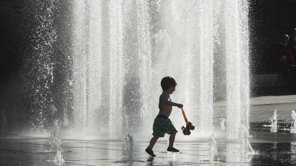 Un nen es refresca contra la calor en una font