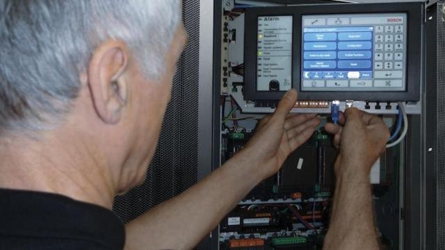 Un técnico cambiando una de las alarmas de un edificio municipal / ARCHIVO