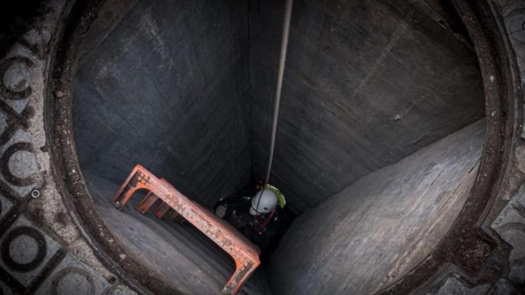 Un agente de la Unidad de Subsuelo baja por la alcantarilla de la calle de València / PABLO MIRANZO