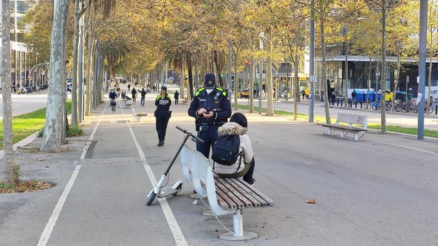 Un agente de la Guardia Urbana multa a una usuaria de patinete eléctrico en Barcelona / EUROPA PRESS