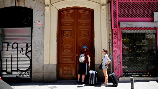 Dos turistas esperan frente a un apartamento turístico en Barcelona