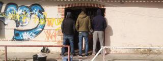 Tres de los ocho hombres que viven okupando el viejo campo de la Damm en Porta / GUILLEM ANDRÉS