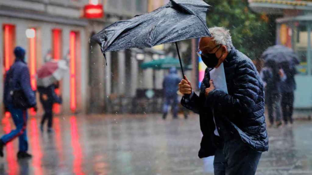 Un hombre pasea bajo la lluvia en la capital catalana / EUROPA PRESS