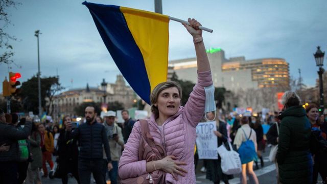 Una mujer levanta una bandera ucraniana en una protesta contra la invasión rusa en Barcelona / METRÓPOLI