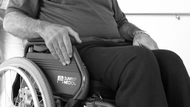 Una mujer ayudando a un hombre en silla de ruedas /FJF