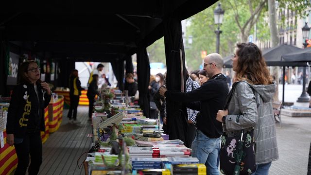 Personas comprando libros en una parada durante la 'diada' de Sant Jordi / LUIS MIGUEL AÑÓN