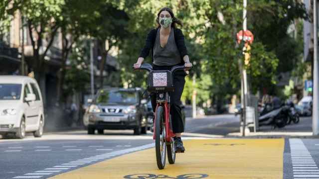Una ciclista con mascarilla en Bicing por la calle de Pau Claris / AYUNTAMIENTO DE BARCELONA