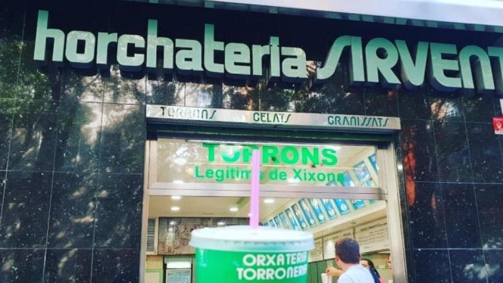Un client sosté un got d'orxata davant l'orxateria Sirvent / INSTAGRAM