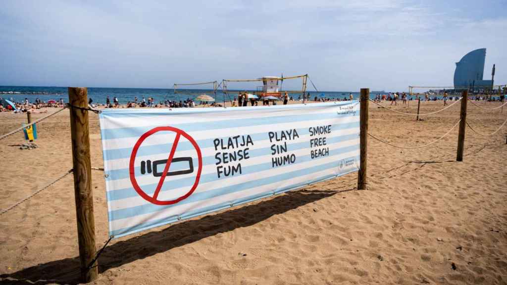 Cartell de prohibició de platges sense fum a la Barceloneta / LUIS MIGUEL AÑÓN (MA)